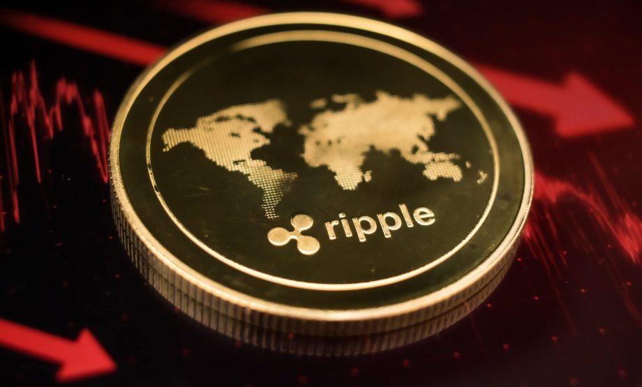 Eine goldene XRP-Münze mit dem Ripple-Logo und einer Weltkarte ruht auf einer dunklen Oberfläche, die von roten Finanzdiagrammlinien beleuchtet wird.