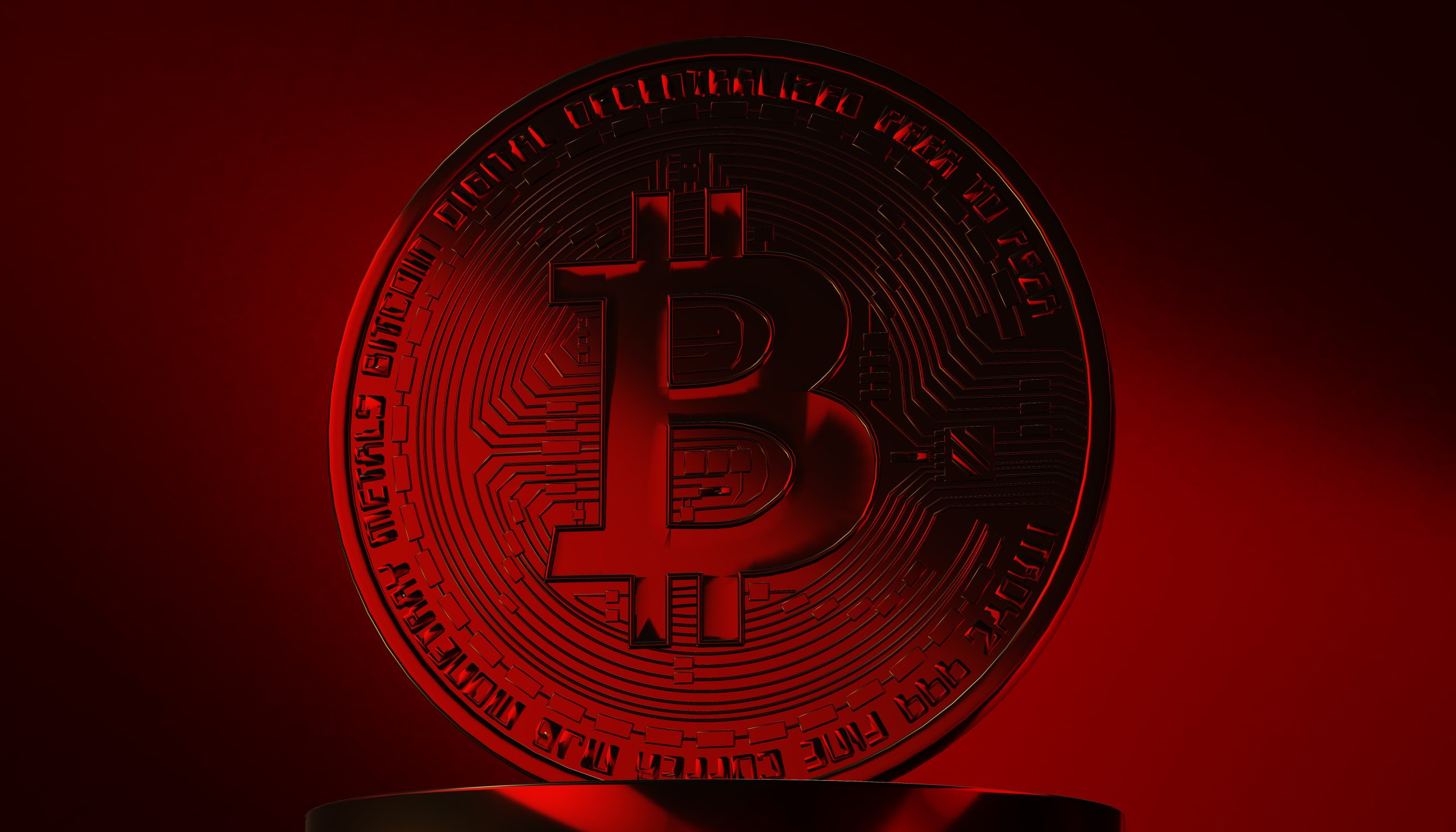 Eine Bitcoin-Münze vor rotem Hintergrund