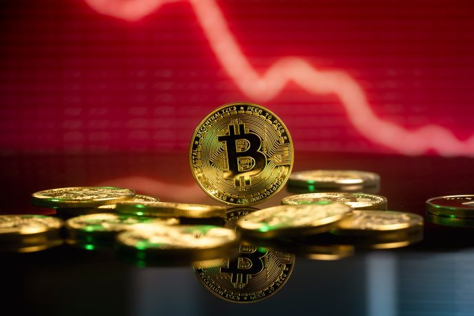 Bitcoin vor rotem Hintergrund, der fallende Kurse symbolisiert