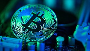 Eine Bitcoin-Münze liegt auf einem Computerchip