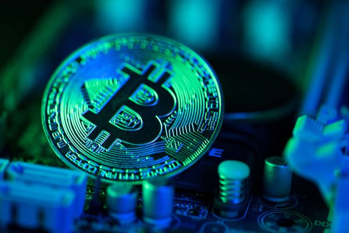 Eine Bitcoin-Münze liegt auf einem Computerchip