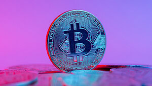 Eine Bitcoin-Münze vor einem blauen Hintergrund