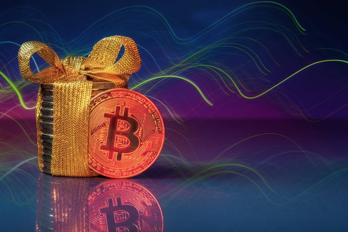 Bitcoin mit einem goldenen Geschenk und einem blau-lila Hintergrund.