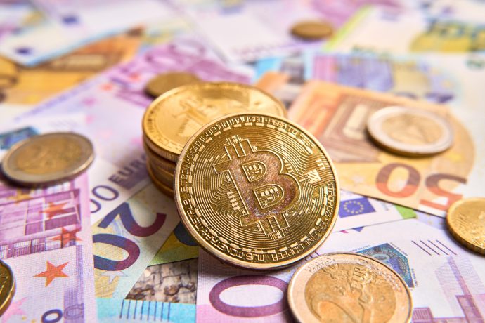 Die Grafik zeigt Bitcoin-Münzen auf Geldscheinen