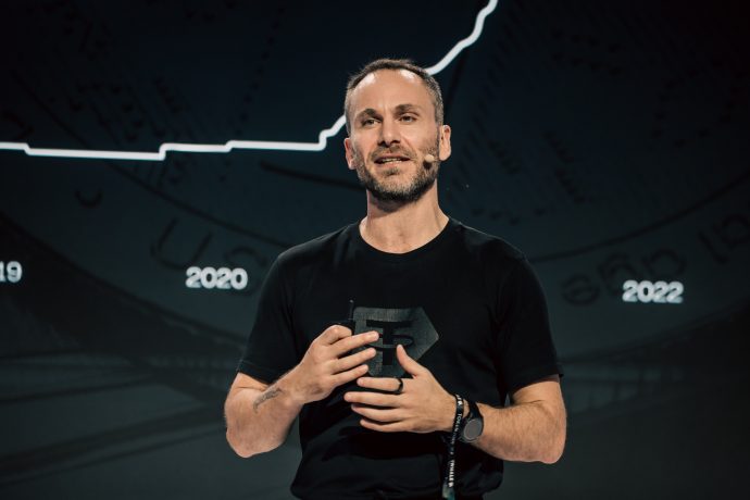 Paolo Ardoino vor einem Bitcoin-Chart