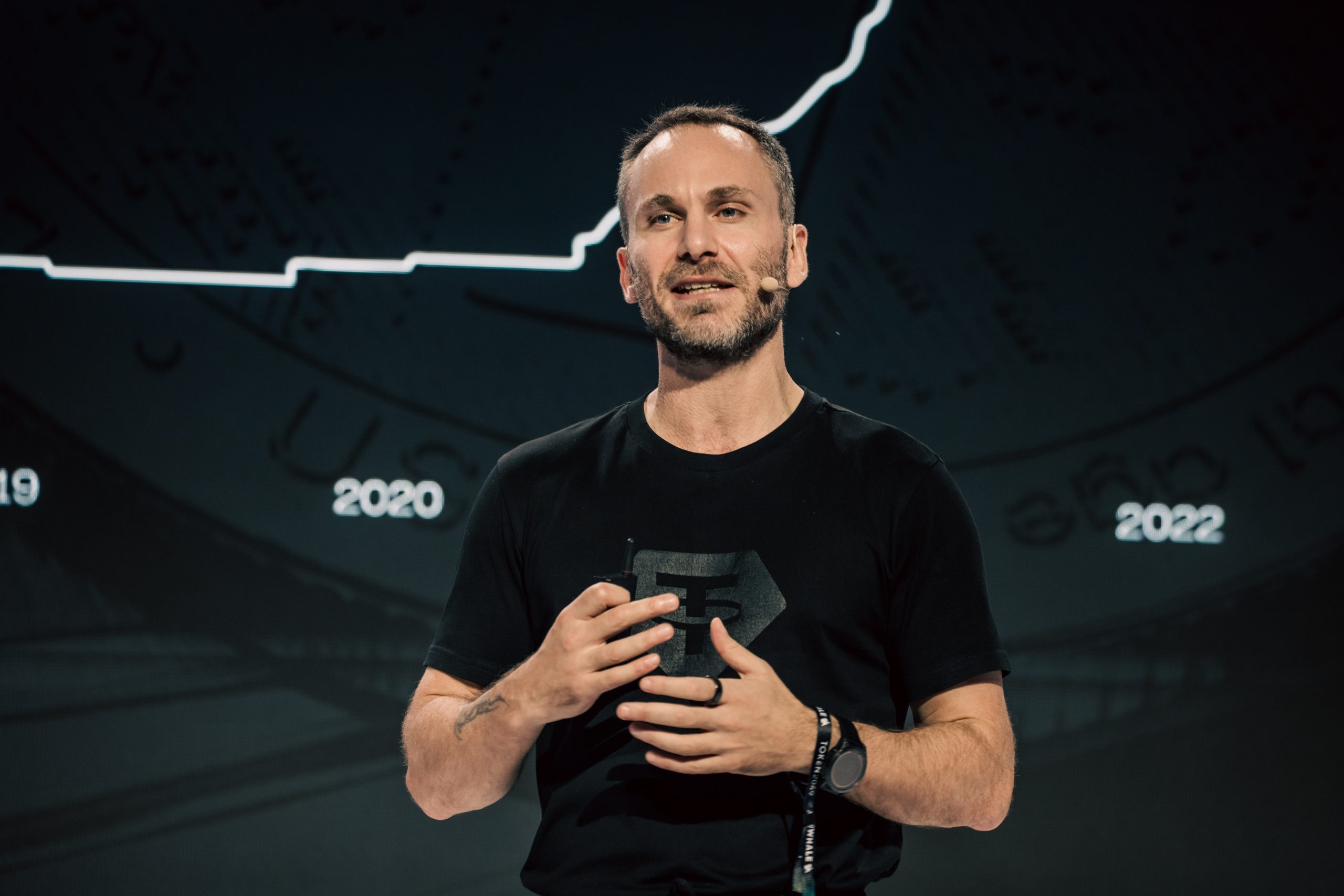 Paolo Ardoino vor einem Bitcoin-Chart