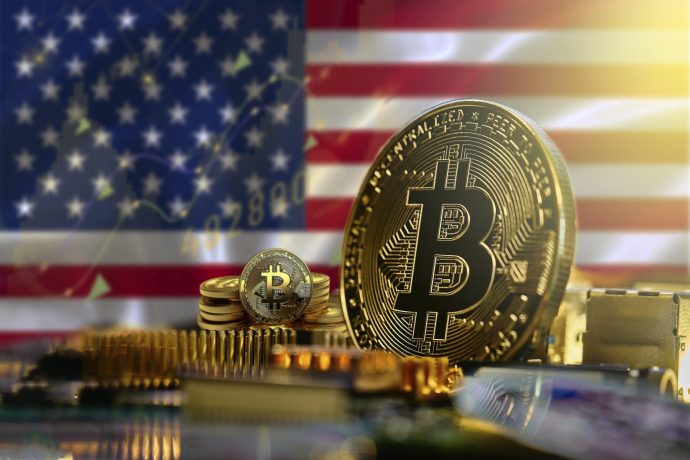 Bitcoin-Münze vor einer US-Flagge