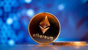 Eine goldene Ethereum-Münze vor einem blauen Hintergrund