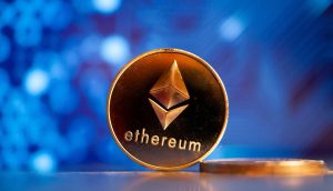 Eine goldene Ethereum-Münze vor einem blauen Hintergrund