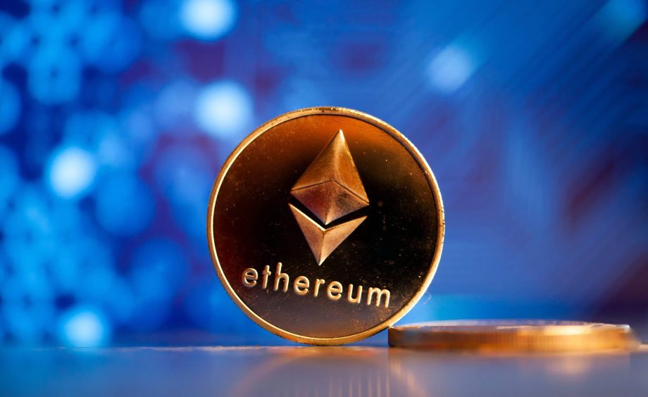 Eine goldene Ethereum-Münze vor einem blauen Hintergrund