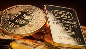 Bitcoin-Münzen neben einem Goldbarren