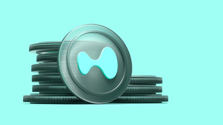 Ein Stapel Hyperliquid-Münzen vor einem türkisen Hintergrund