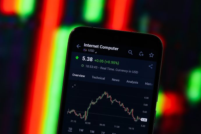 Hand hält Smartphone, auf dem das Logo von Internet Computer zu sehen ist