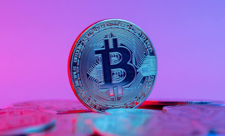 Eine Bitcoin-Münze vor einem blauen Hintergrund.