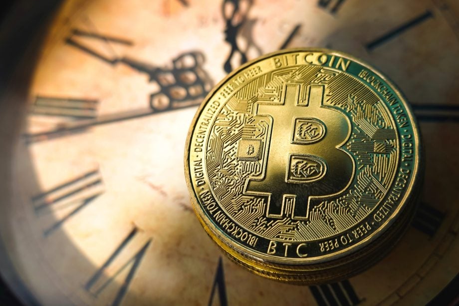 Bitcoin vor dem Hintergrund einer Uhr