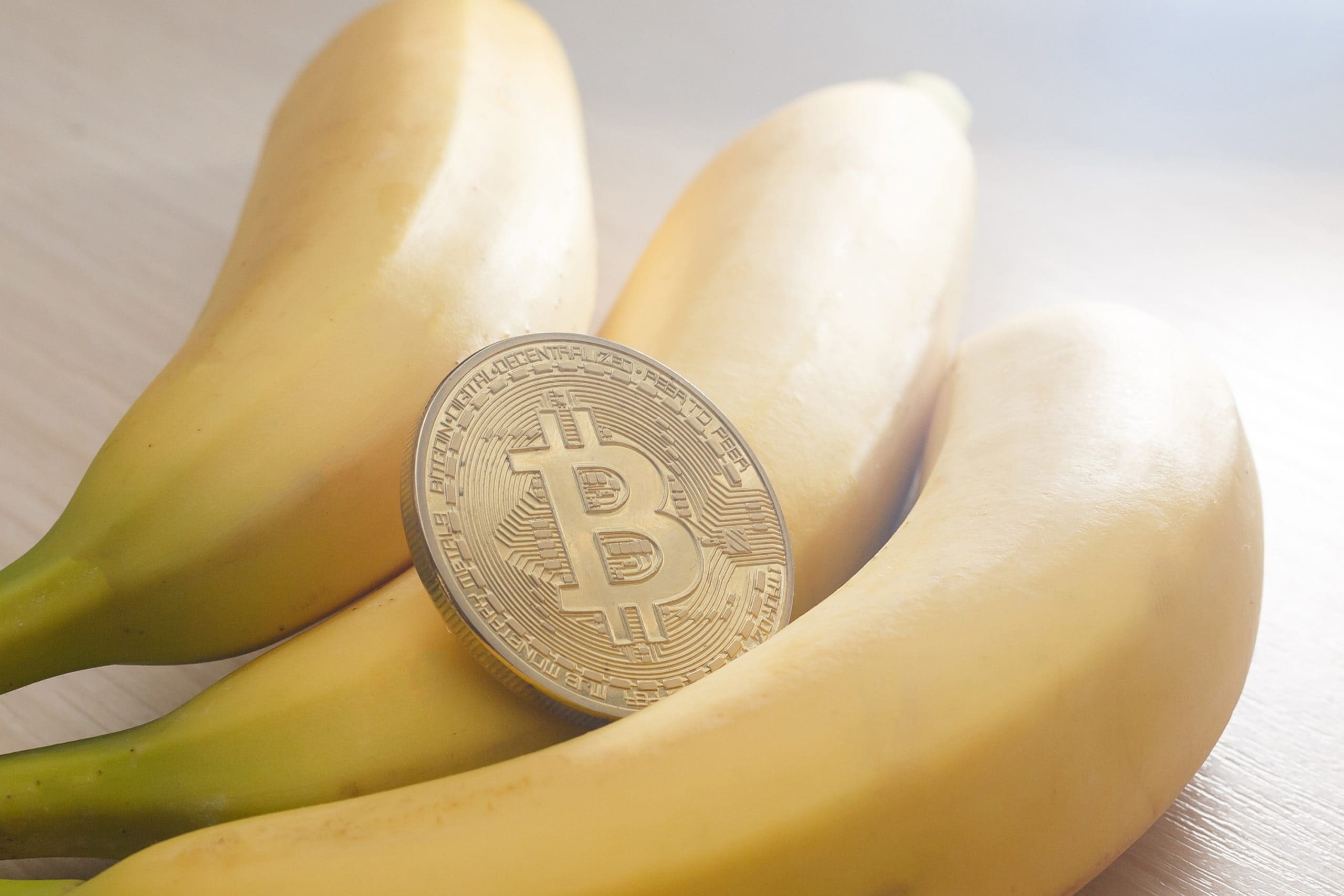 Bitcoin-Münze und drei Bananen