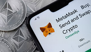 MetaMask-Wallet auf Display von Smartphone, das auf Ethereum-Münzen liegt