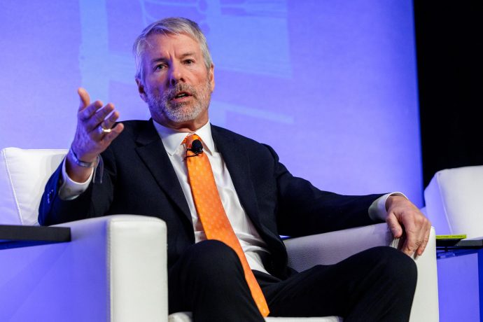 Michael Saylor sitzt auf Stuhl auf Bühne