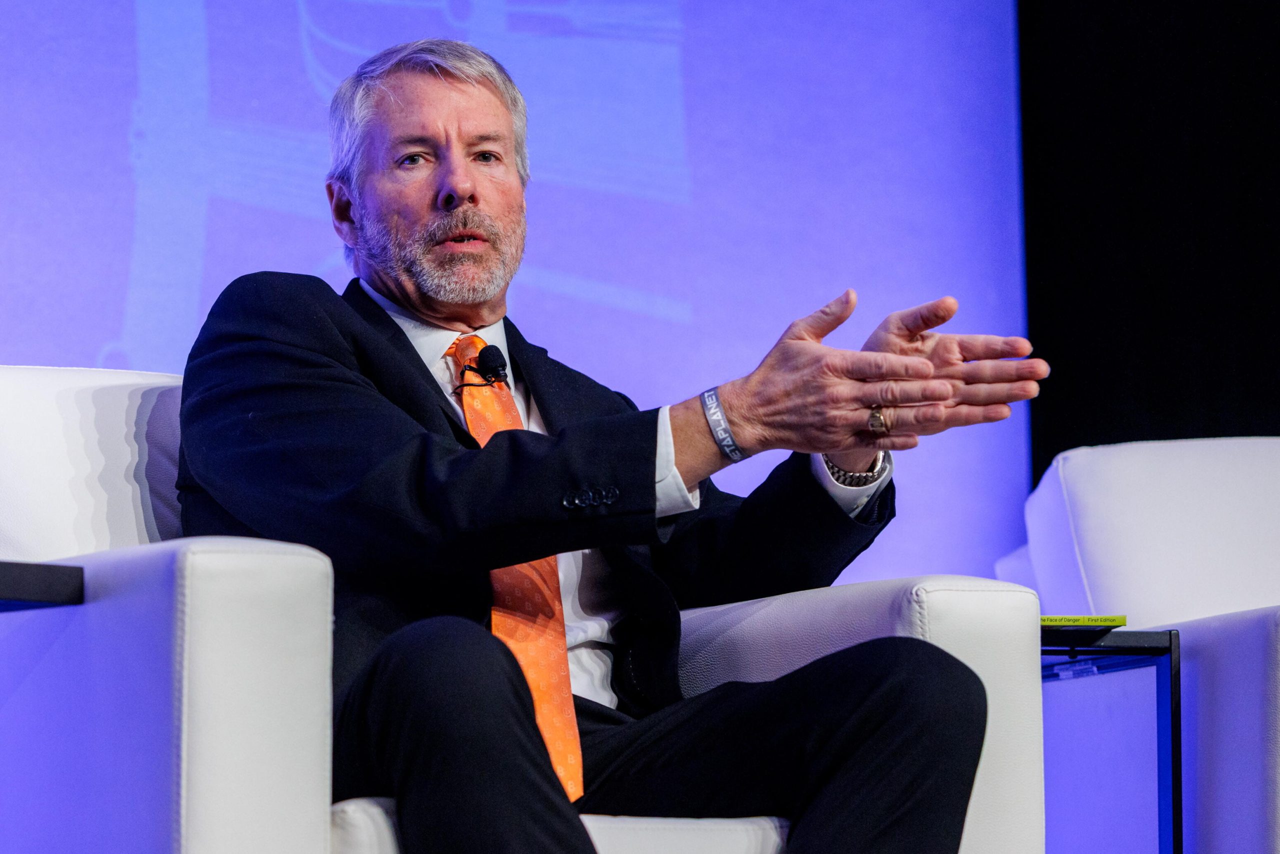 Michael Saylor sitzt mit oranger Krawatte bei einer Konferenz