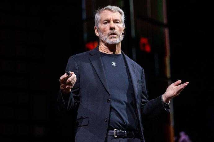 Ein Mann mit grauen Haaren steht auf einer Bühne.
