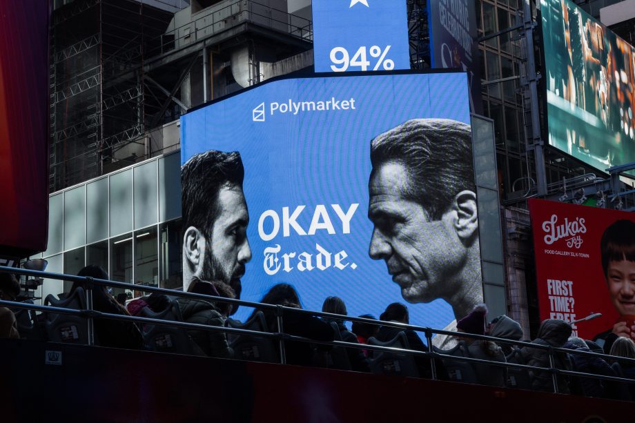 Eine Werbefläche in New York zeigt eine Werbung von Polymarket. Auf ihr stehen sich zwei Personen gegenüber, dazwischen steht "Okay Trade".