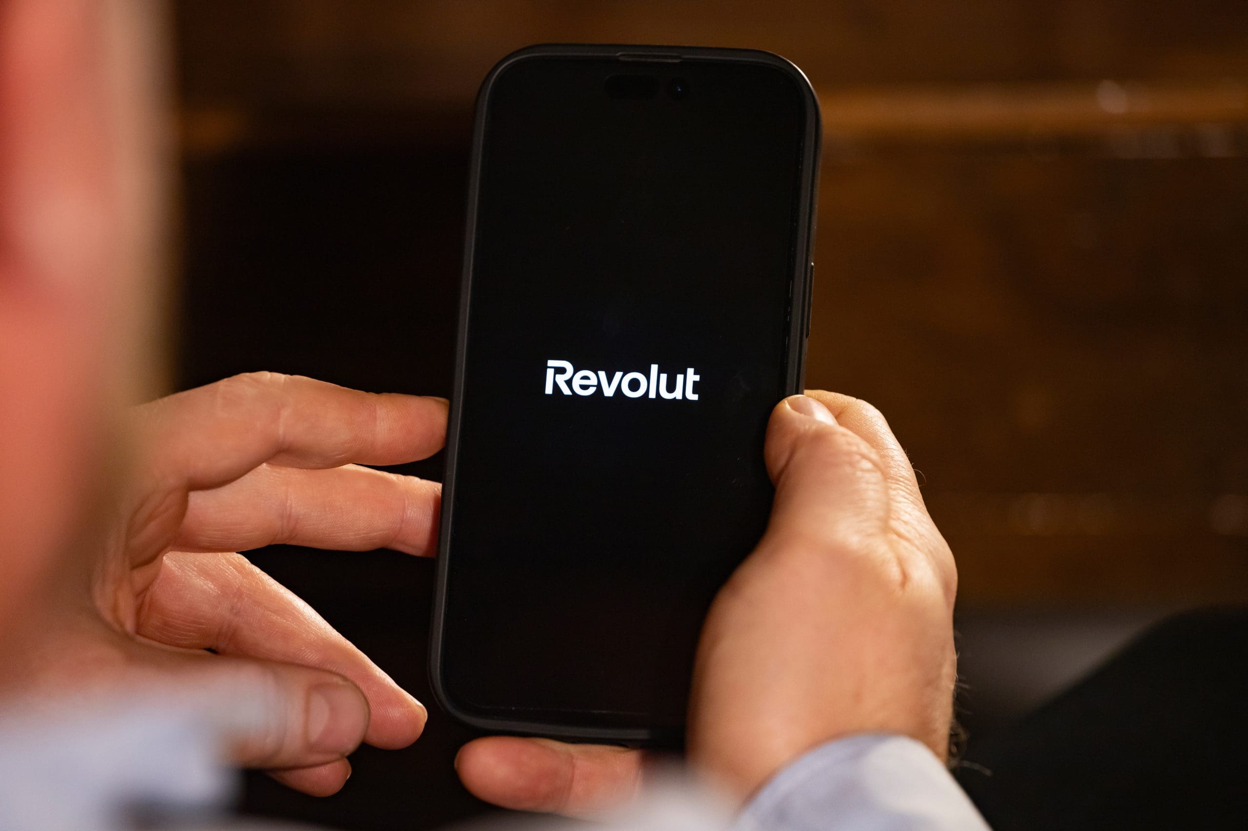 Ein Nutzer hält sein Smartphone mit der Revolut-App