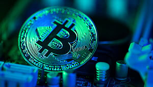 Eine Bitcoin-Münze liegt auf einem Computerchip