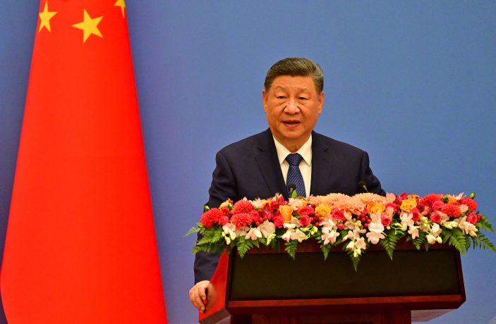Chinas Präsident Xi hält eine Rede. Hinter ihm weht die chinesische Flagge.