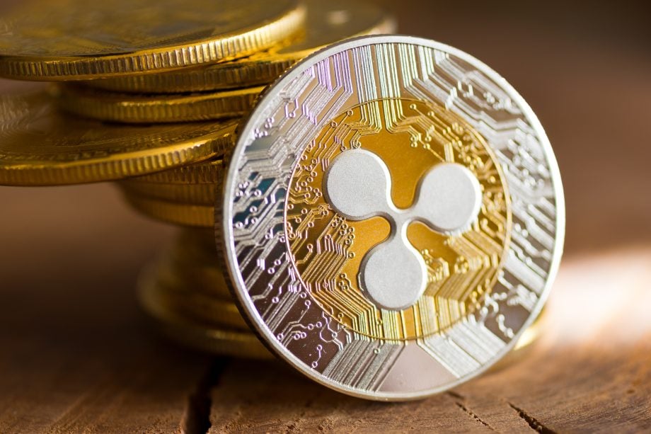 Eine XRP-Münze steht aufrecht auf einem hölzernen Untergrund