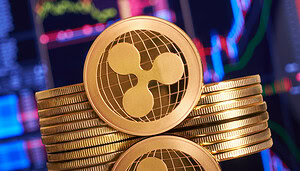 Zu sehen ist eine Münze der Kryptowährung XRP, die vor einem Stapel weiterer Münzen steht , vor einem Chart als Hintergrund