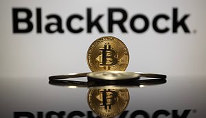 Eine Bitcoin-Münze steht vor dem Logo von BlackRock.
