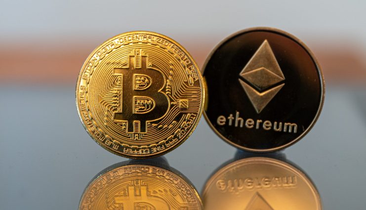 Bitcoin und Ethereum befinden sich zum Jahresstart im Aufwind Bitcoin- und Ethereum-Münze stehen auf Tisch