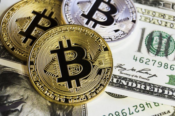 Bitcoin-Münzen liegen auf US-Dollarscheine