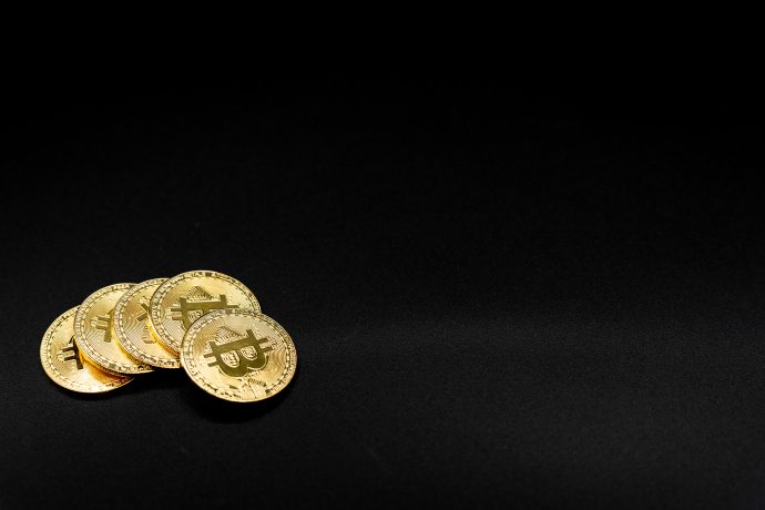 Bitcoin Münzen vor schwarzem Hintergrund