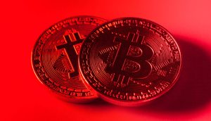 Zwei Bitcoin-Münzen vor rotem Hintergrund