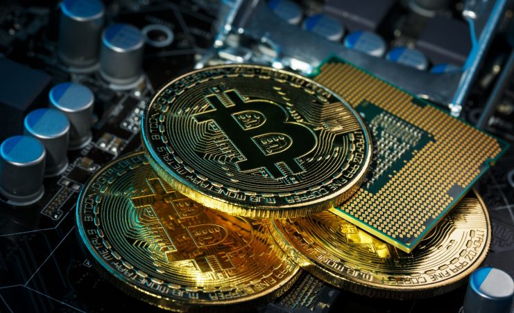 Wie sichert man Bitcoin am besten? Drei Bitcoin-Münzen liegen auf den Sicherheitselementen einer Hardware Wallet.