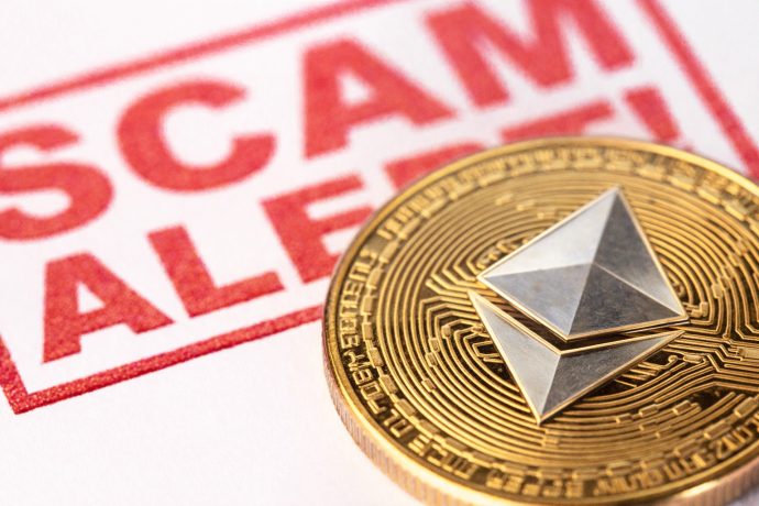 Eine Ethereum-Münze liegt vor einem Stempel, auf dem "Scam Alert" steht.