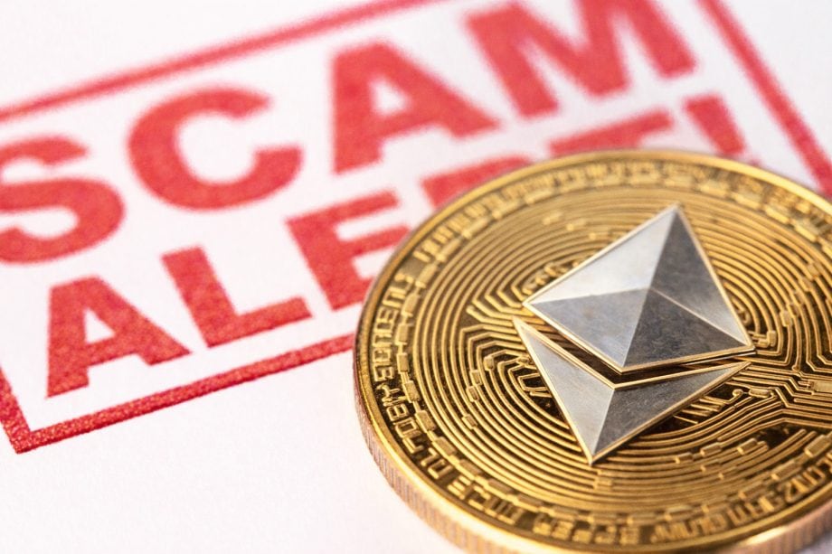 Eine Ethereum-Münze liegt vor einem Stempel, auf dem "Scam Alert" steht.