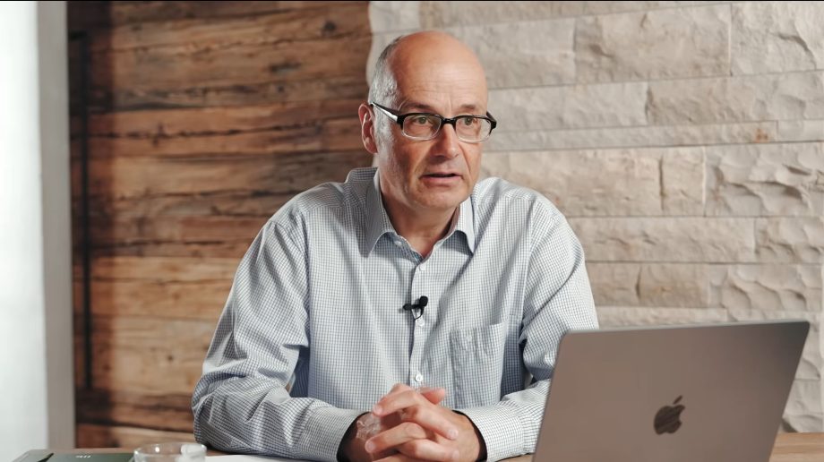 Andreas Beck sitzt mit seinem MacBook an einem Schreibtisch und spricht über das Global Portfolio One