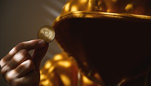 Das Bild zeigt einen Mann und eine Bitcoin-Münze