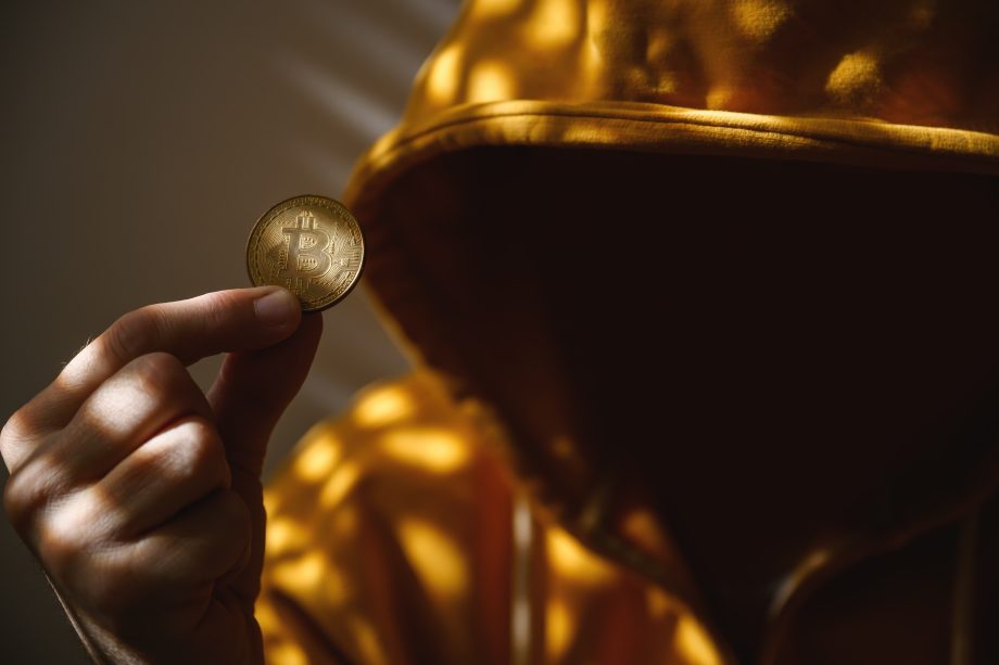 Das Bild zeigt einen Mann und eine Bitcoin-Münze