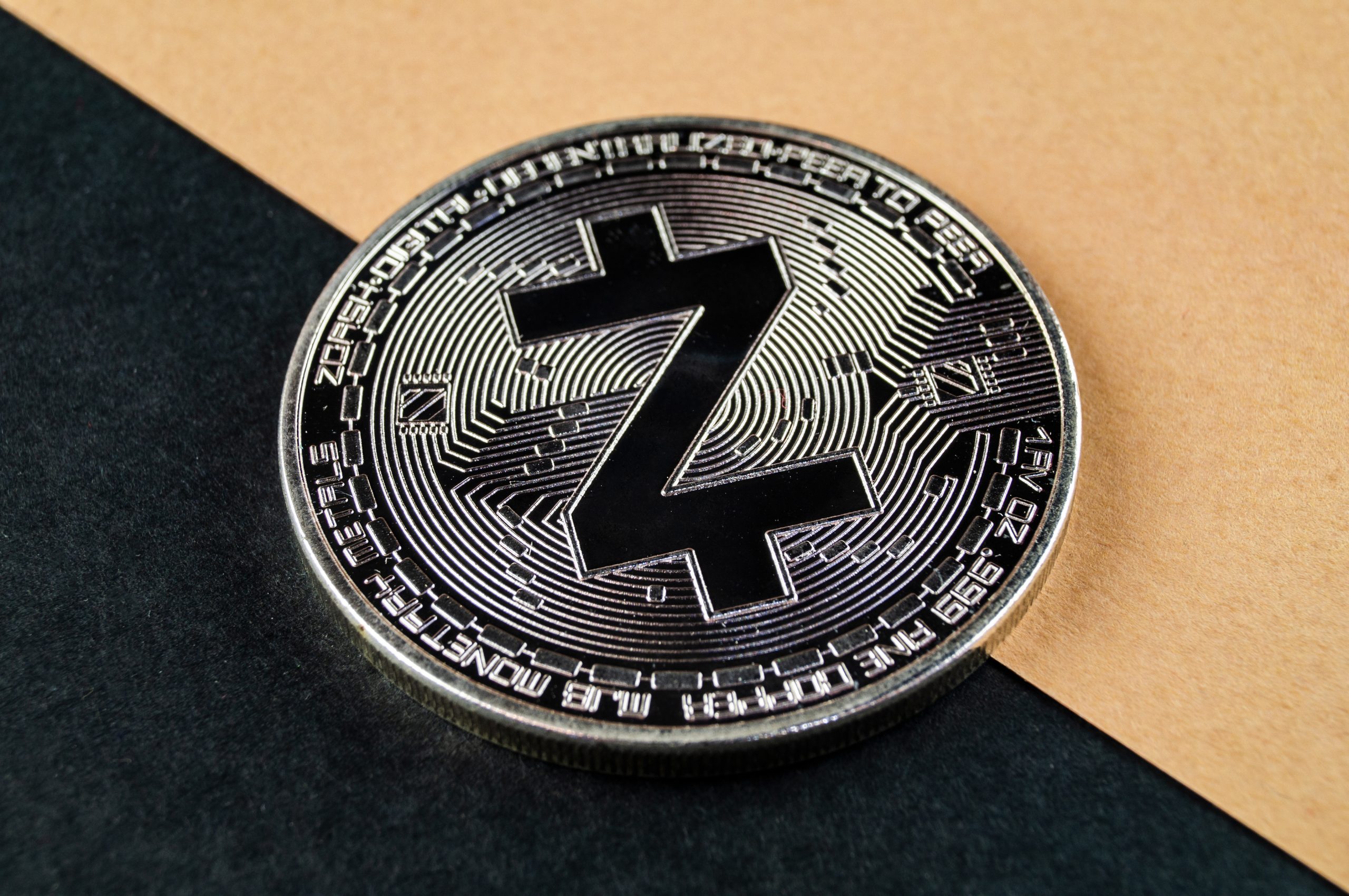 Eine Zcah-Münze liegt auf einem schwarz/gelben Hintergrund