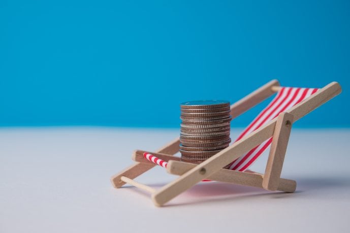 Das Bild zeigt Münzen auf einem Strandstuhl