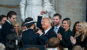 Das Bild zeigt die Trump-Familie bei der Amtseinführung Donald Trumps, der in der Mitte des Bildes steht und die Faust in die Luft reckt.