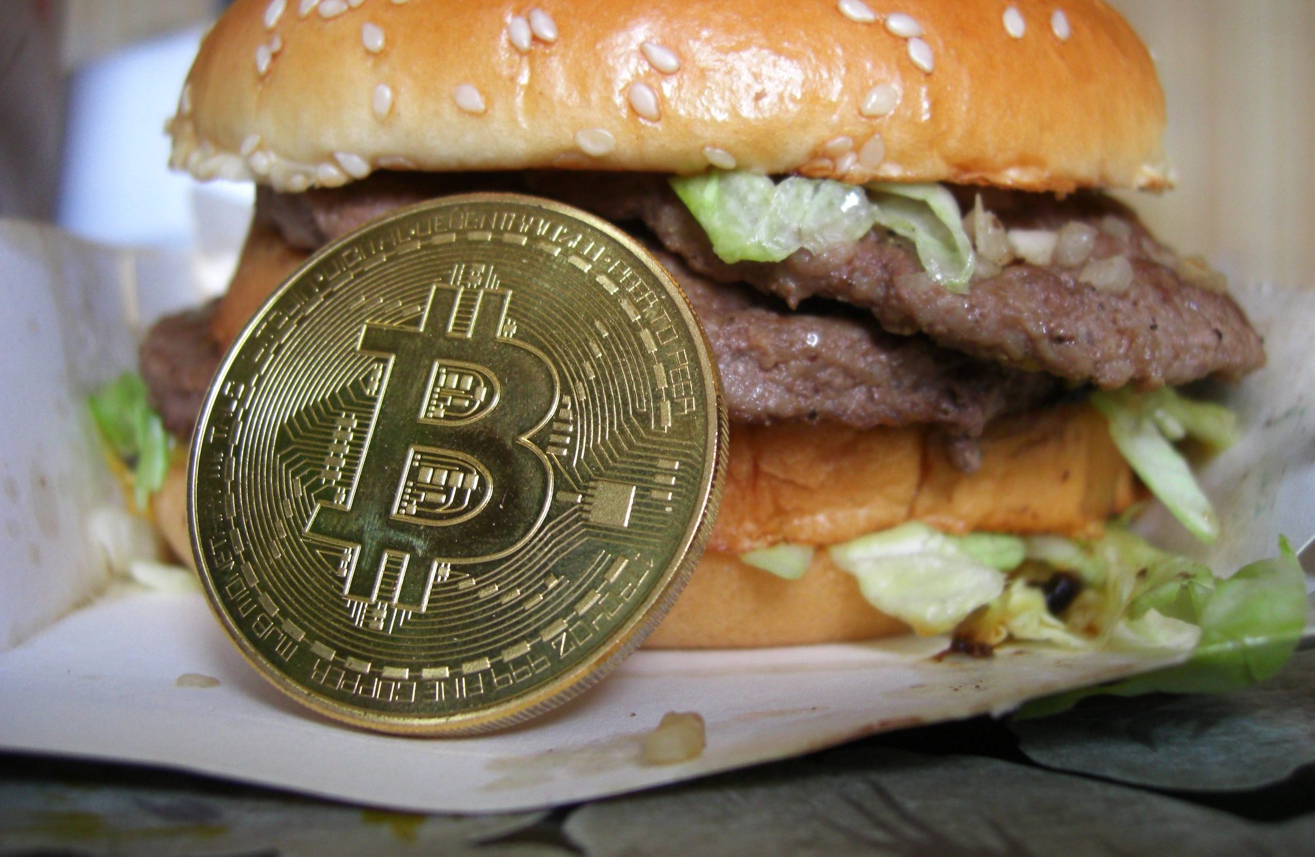 Bitcoin-Münze und ein saftiger Burger
