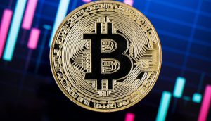 Eine Bitcoin-Münze vor einem Kurschart.