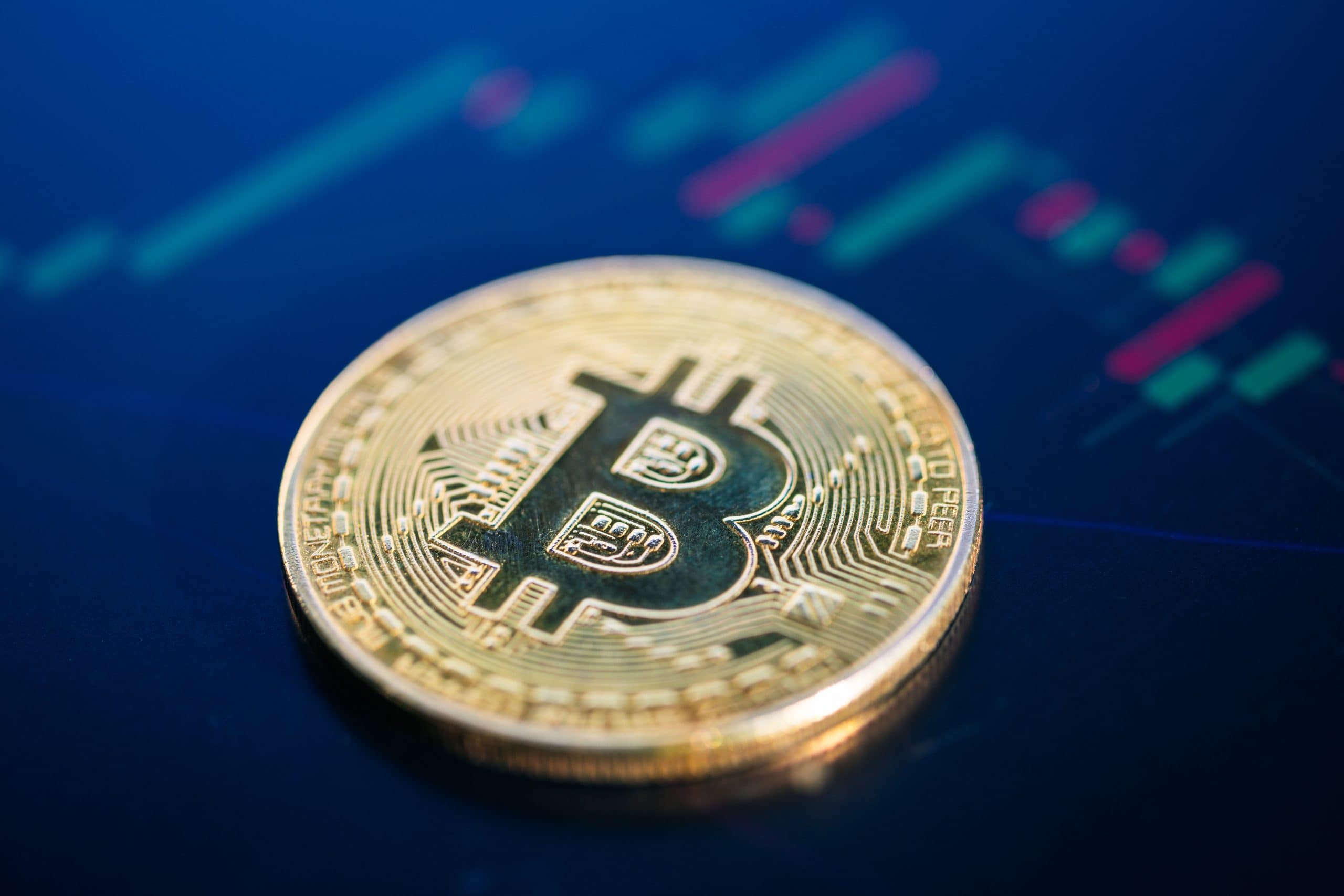 Eine Bitcoin-Münze vor einem Charthintergrund