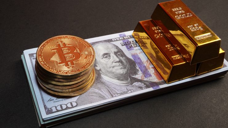 Die Grafik zeigt Bitcoin-Münzen und Goldbarren auf einem US-Dollarschein