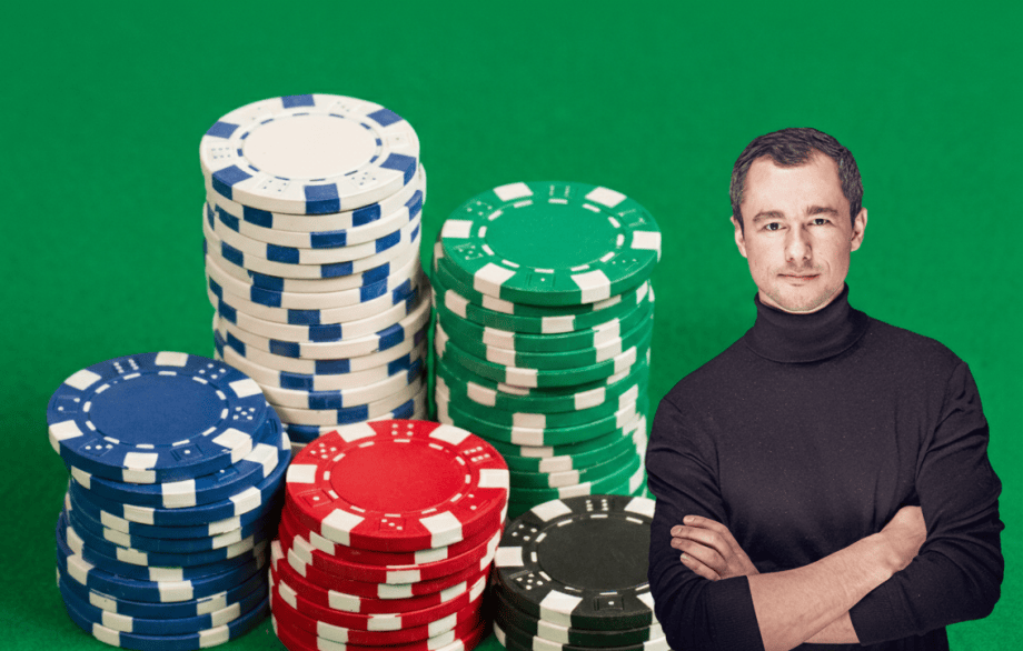 Mehrere bunte Pokerchips sind vor einem grünen Hintergrund in Stapel aufgeteilt. Rechts auf dem Bild steht ein Mann mit schwarzem Rollkragenpullover.