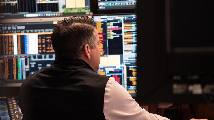 Der Tech-Sektor dominiert das Kursgeschehen Ein Trader sitzt vor einem Bildschirm mit Finanzdaten